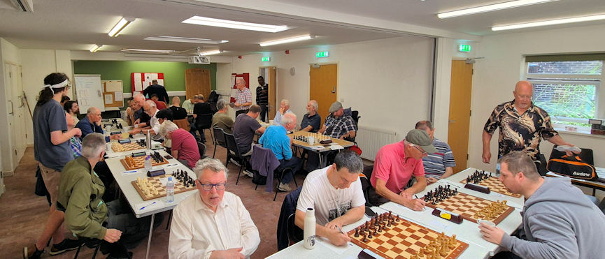 View of chess players sat ready to play in a big hall.